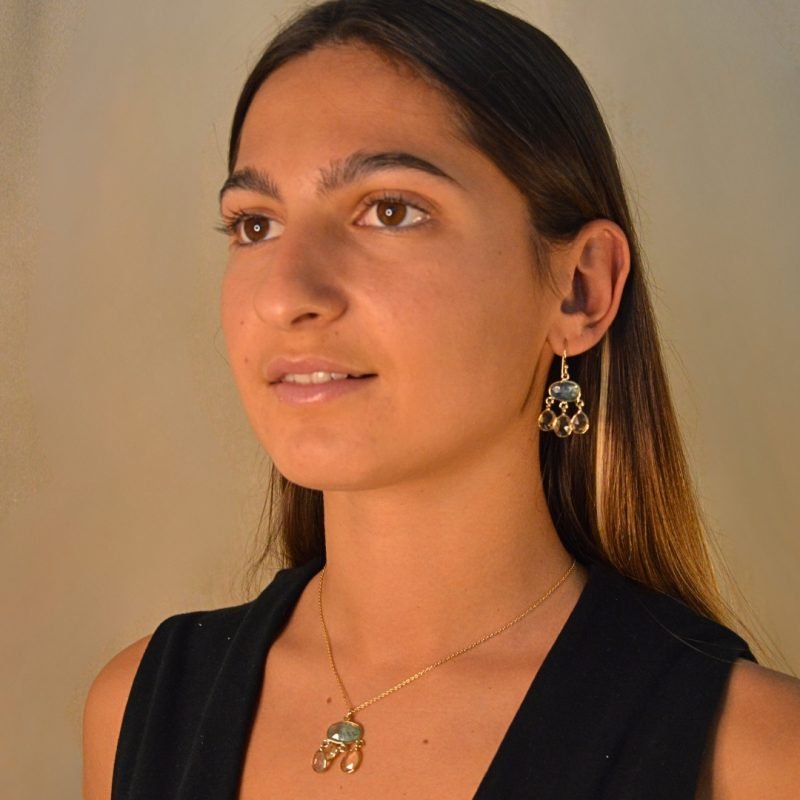 Adèle sont de superbes boucles d'oreilles en plaqué or 3 microns pendantes ornées de citrine étincelante et de trois kyanites vertes.. Bijou porté, Crédit GEMITY.