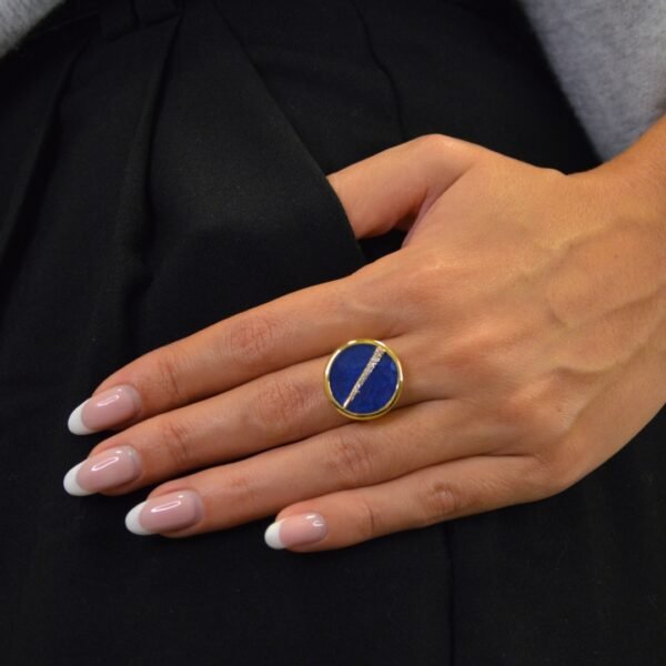 Bague plaquée or ronde intérieur en lapis lazuli (bleu) avec un trait esthétique brillant dans son diamètre. Bijou porté, Crédit GEMITY.