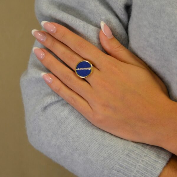 Bague plaquée or ronde intérieur en lapis lazuli (bleu) avec un trait esthétique brillant dans son diamètre. Bijou porté, Crédit GEMITY.