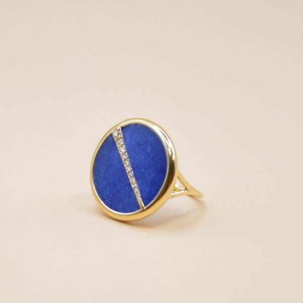 Bague plaquée or ronde intérieur en lapis lazuli (bleu) avec un trait esthétique brillant dans son diamètre. Bijou seul, Crédit Léo Sédim