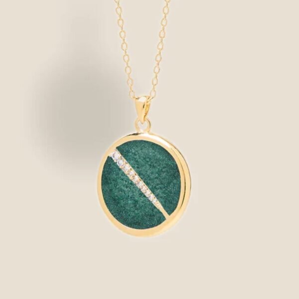 Collier plaquée or avec pendentif rond intérieur en jaspe (verte) avec un trait esthétique brillant dans son diamètre. Bijou seul, Crédit Léo Sédim