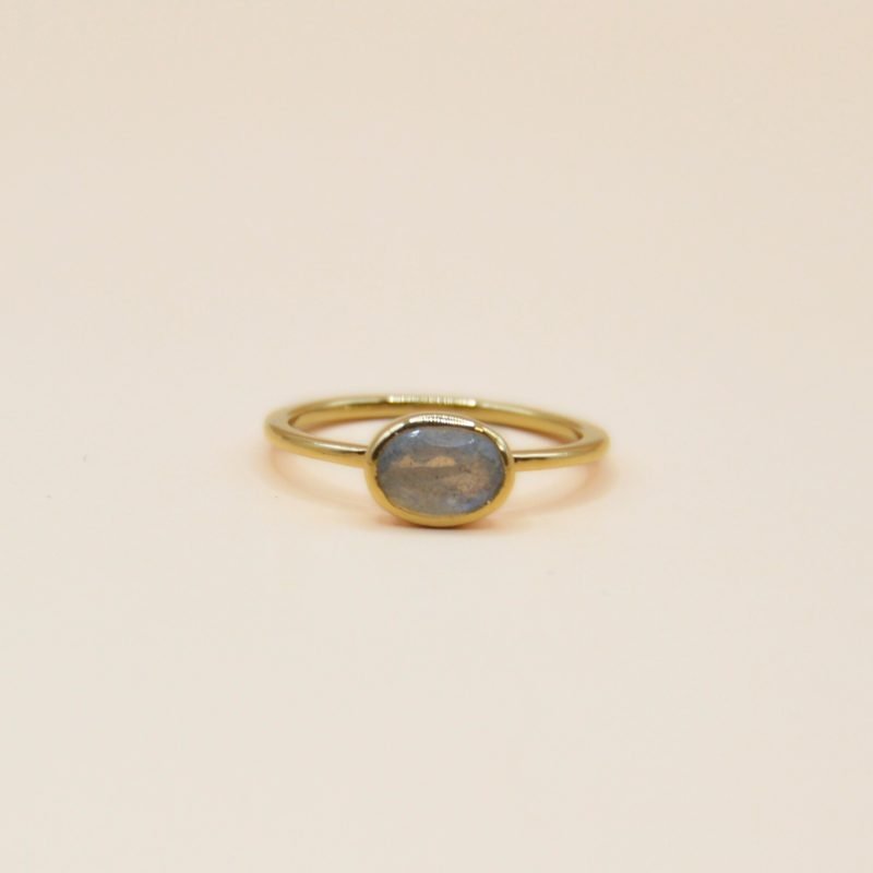 Notre bague Candice est le symbole même de l'élégance minimaliste. Confectionnée en plaqué or 3 microns, cette bague fine et délicate met en valeur la beauté naturelle de la pierre Labradorite ovale qui trône au centre. . Bijou seul, Crédit GEMITY