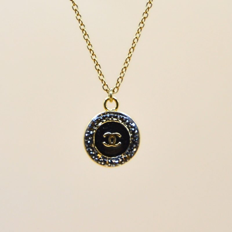 Upcycling d’un bouton noir à strass d’une maison de luxe monté en pendentif sur une chaîne de mailles fines (2 mm) d’une longueur de 50 cm. Bijou seul, Crédit GEMITY. Upcycling d’un bouton noir à strass d’une maison de luxe monté en pendentif sur une chaîne de mailles fines (2 mm) d’une longueur de 50 cm