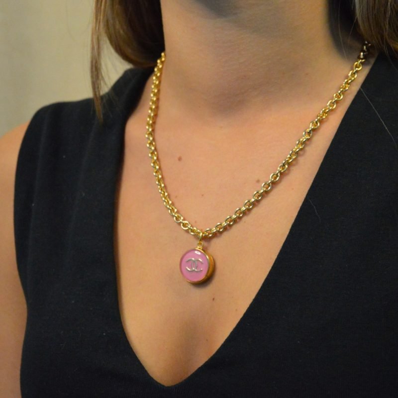 Upcycling d’un bouton rose d’une maison de luxe monté en pendentif sur une chaîne de mailles épaisses (5 mm) d’une longueur de 50 cm. Bijou seul, Crédit GEMITY. Upcycling d’un bouton rose d’une maison de luxe monté en pendentif sur une chaîne de mailles épaisses (5 mm) d’une longueur de 50 cm. Bijou porté, Crédit GEMITY.