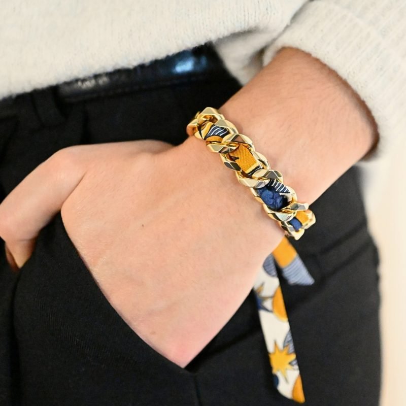 Choisissez ce magnifique bracelet pour le plaisir de toutes celles qui aiment les bijoux à accumuler et les chaînes. Ce bracelet est accompagné du ruban cirque des rêves neutre. Bijou porté, Crédit GEMITY.