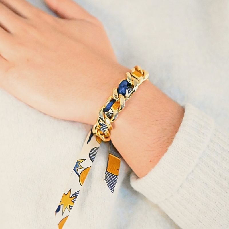 Choisissez ce magnifique bracelet pour le plaisir de toutes celles qui aiment les bijoux à accumuler et les chaînes. Ce bracelet est accompagné du ruban cirque des rêves neutre. Bijou porté, Crédit GEMITY.