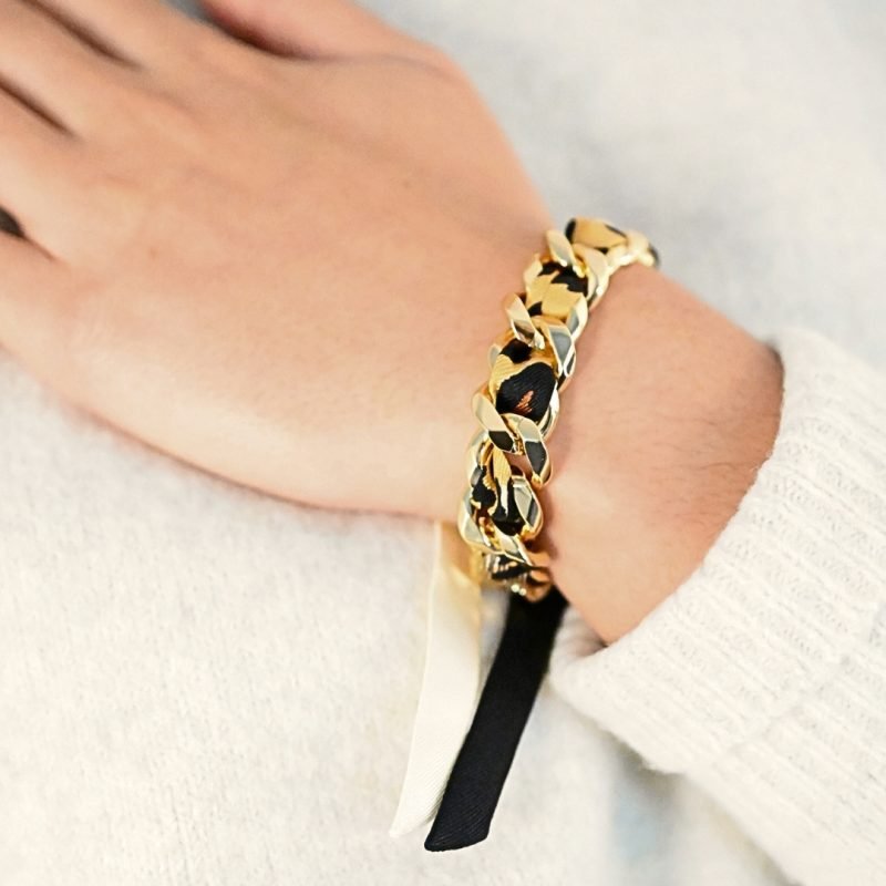 Choisissez ce magnifique bracelet pour le plaisir de toutes celles qui aiment les bijoux à accumuler et les chaînes. Ce bracelet est accompagné du ruban léopard. Bijou porté, Crédit GEMITY.