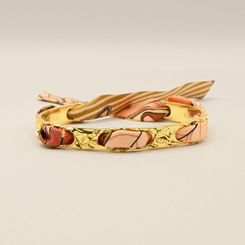 Le bracelet FÉERIE est un des intemporels les plus appréciés de la marque, pour celles qui recherchent le raffinement et la discrétion. C'est le bracelet le plus fin de nos créations (0,8 cm de largeur), travaillé de petites lianes et feuilles, il est à la fois très élégant et poétique. Ce bracelet est accompagné du ruban carrousel neutre. Bijou seul, Crédit GEMITY
