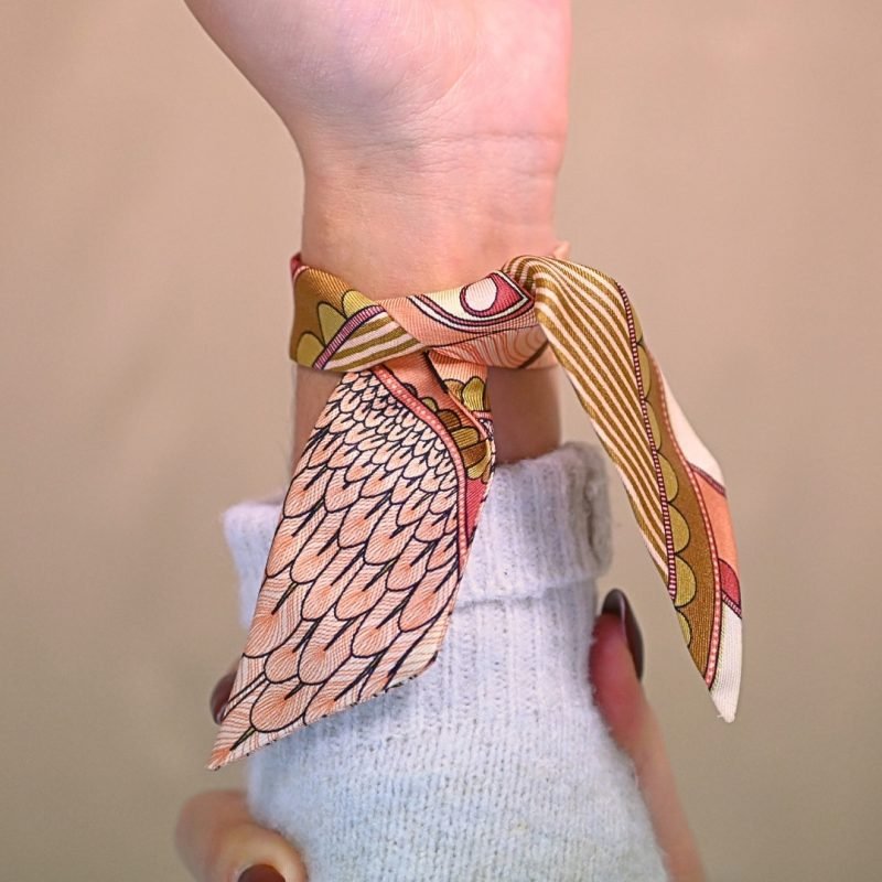 Voici notre nouvel ornement dédié à nos rubans en soie de 4 cm. Une vraie beauté inspirée de l'univers du Cirque, incrustée d'un strass facetté tie & dye rose (bicolore). Cet ornement est porté avec le ruban carrousel neutre. Bijou porté, Crédit GEMITY