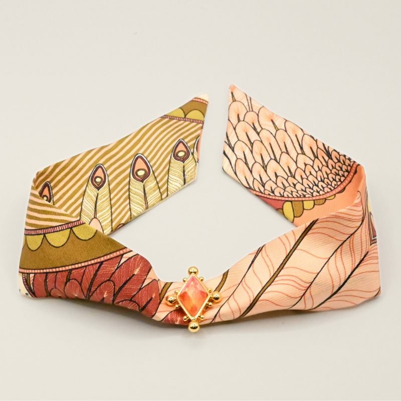 Voici notre nouvel ornement dédié à nos rubans en soie de 4 cm. Une vraie beauté inspirée de l'univers du Cirque, incrustée d'un strass facetté tie & dye rose (bicolore). Cet ornement est porté avec le ruban carrousel neutre. Bijou seul, Crédit GEMITY