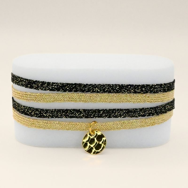 "Bracelet double tours en tissu de deux coloris différents avec une pastille martelée dorée à l’or fin. Fermoir en plaqué or réglable . Bijou seul, Crédit GEMITY"