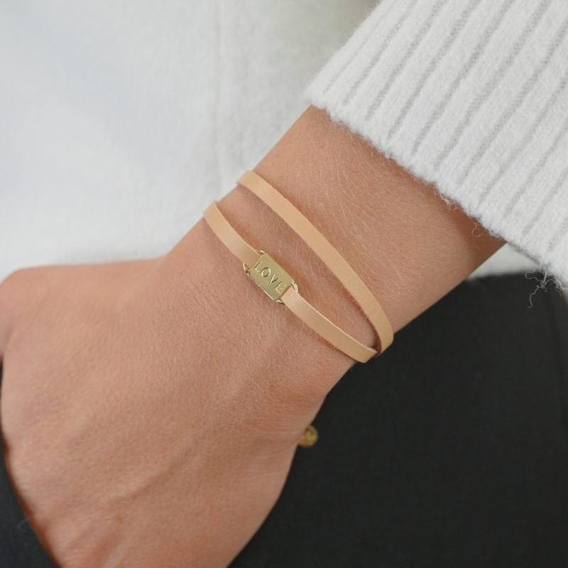 Bracelet double tours avec une plaque LOVE en plaqué or (3 microns) fait main. Fermoir en plaqué or réglable. Bijou porté, Crédit GEMITY.