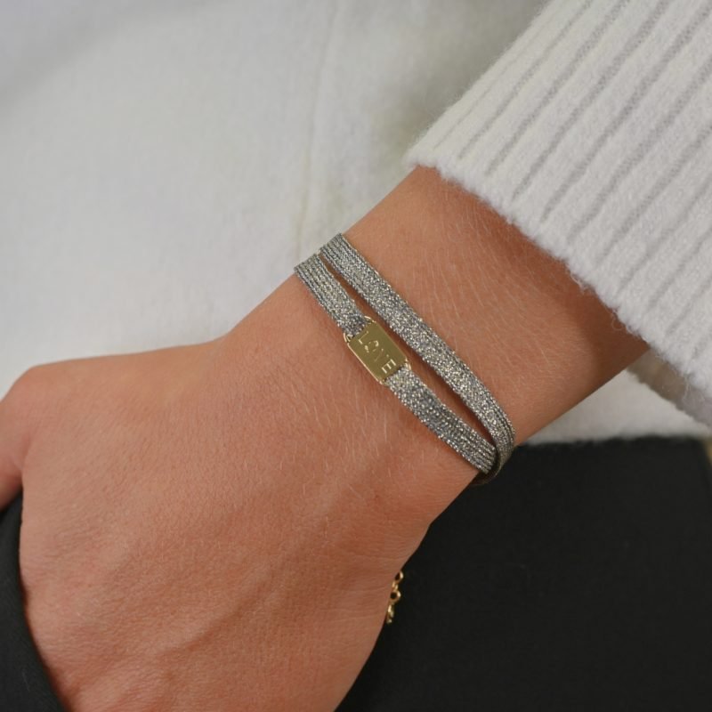 "Bracelet double tours avec une plaque LOVE en plaqué or (3 microns) fait main. Fermoir en plaqué or réglable . Bijou porté, Crédit GEMITY."