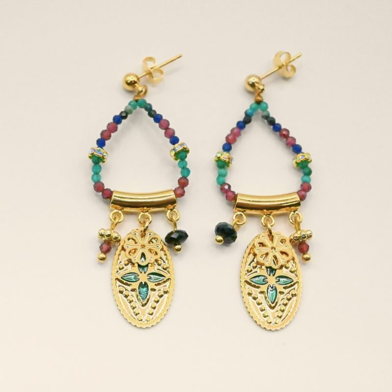 Ces boucles d’oreilles sont un véritable hommage à l’art indien. Chaque pièce est façonnée et émaillée à la main, mettant en valeur le savoir-faire traditionnel. Les pendentifs ovales évoquent des éléments floraux tels que le lotus, symbole porte-bonheur. Bijou seul, Crédit GEMITY