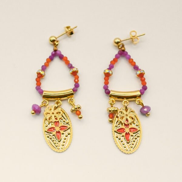 Ces boucles d’oreilles sont un véritable hommage à l’art indien. Chaque pièce est façonnée et émaillée à la main, mettant en valeur le savoir-faire traditionnel. Les pendentifs ovales évoquent des éléments floraux tels que le lotus, symbole porte-bonheur. Bijou seul, Crédit GEMITY