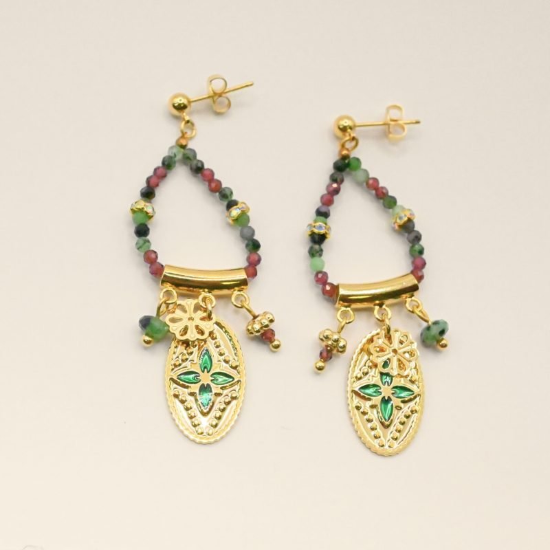 Ces boucles d’oreilles sont un véritable hommage à l’art indien. Chaque pièce est façonnée et émaillée à la main, mettant en valeur le savoir-faire traditionnel. Les pendentifs ovales évoquent des éléments floraux tels que le lotus, symbole porte-bonheur. Bijou seul, Crédit GEMITY