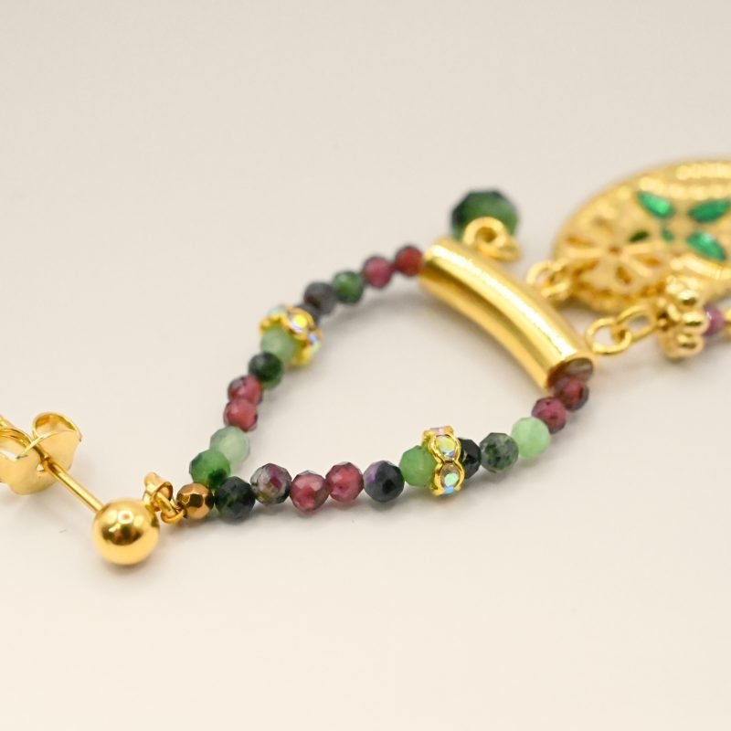 Ces boucles d’oreilles sont un véritable hommage à l’art indien. Chaque pièce est façonnée et émaillée à la main, mettant en valeur le savoir-faire traditionnel. Les pendentifs ovales évoquent des éléments floraux tels que le lotus, symbole porte-bonheur. Bijou seul, Crédit GEMITY