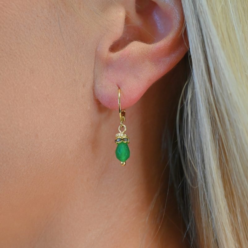 Petites boucles d'oreille parfaites pour le quotidien ou pour être portées en association avec le collier Jaipur par exemple. Elles sont très légères et d'une couleur éclatante. Un anneau strassé vient faire le pont entre la goutte et un petit anneau doré orné de mini boules typiquement indien. Bijou porté, Crédit GEMITY.