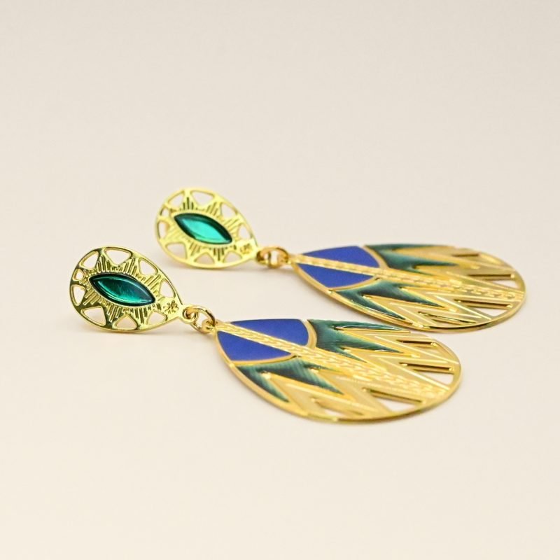 Inspirée des paniers du Sahara, cette paire de boucles d'oreille TANI est très originale par sa combinaison de couleurs et de motifs géométriques. Une tresse gravée fait le lien entre la puce qui habille finement le lobe de l'oreille et la boucle pendante. Bijou seul, Crédit GEMITY