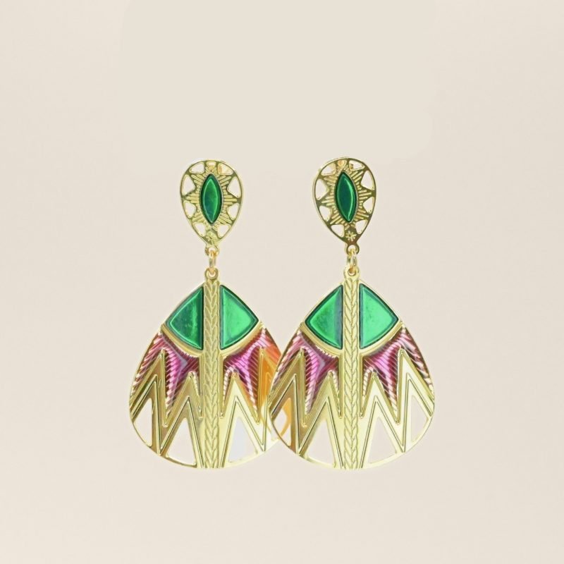 Inspirée des paniers du Sahara, cette paire de boucles d'oreille TANI est très originale par sa combinaison de couleurs et de motifs géométriques. Une tresse gravée fait le lien entre la puce qui habille finement le lobe de l'oreille et la boucle pendante. Bijou seul, Crédit GEMITY