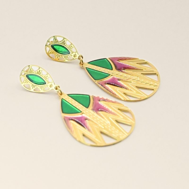 Inspirée des paniers du Sahara, cette paire de boucles d'oreille TANI est très originale par sa combinaison de couleurs et de motifs géométriques. Une tresse gravée fait le lien entre la puce qui habille finement le lobe de l'oreille et la boucle pendante. Bijou seul, Crédit GEMITY