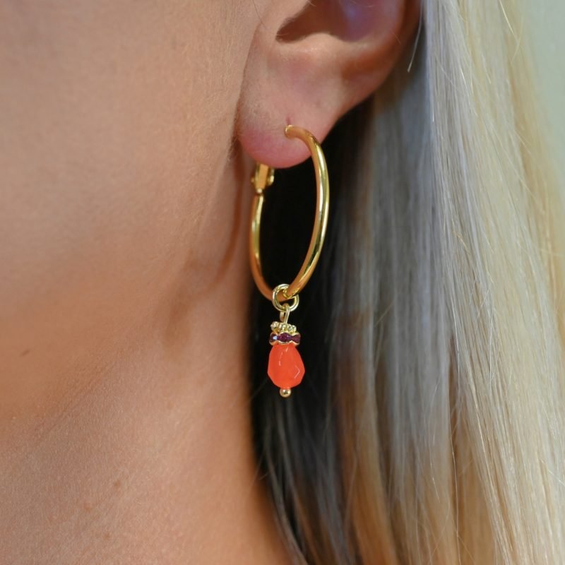 Découvrez l’élégance intemporelle de cette créole doré à l’or fin, ornée d’un délicat pendentif en pierre de jade teinté. Ces boucles d’oreilles allient sophistication et modernité, parfaites pour sublimer toutes vos tenues, qu’elles soient décontractées ou habillées. Bijou porté, Crédit GEMITY.
