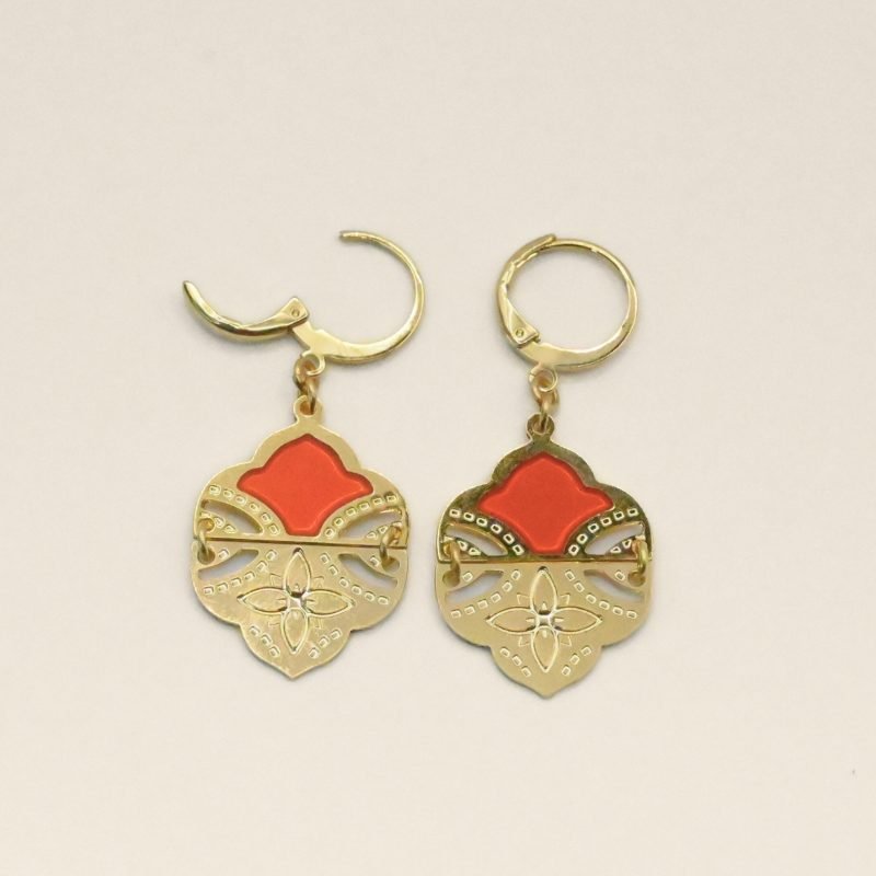 Comme un hommage aux volutes de l'architecture et palais indiens, ces boucles d’oreilles tout en courbes sublimeront votre visage. Elles sont émaillées de résine colorée transparente qui donne de la profondeur à la boucle. Elles sont en 2 parties pour plus de fluidité et de légèreté. La partie inférieure est gravée d'une fleur à 4 pétales. D'un style bohème chic, ce joli modèle vous accompagnera partout. Bijou seul, Crédit GEMITY