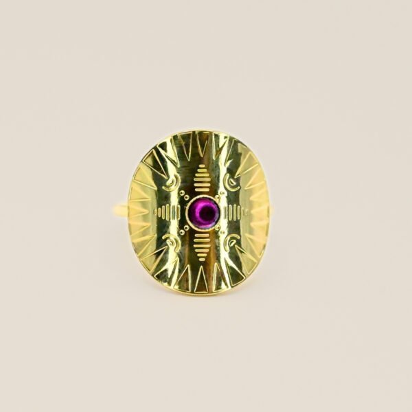 Cette jolie bague habille votre doigt avec son motif rond et courbé. Elle est gravée de motifs et surmonté d'un cabochon de couleur, émaillé à la main. Bijou seul, Crédit GEMITY