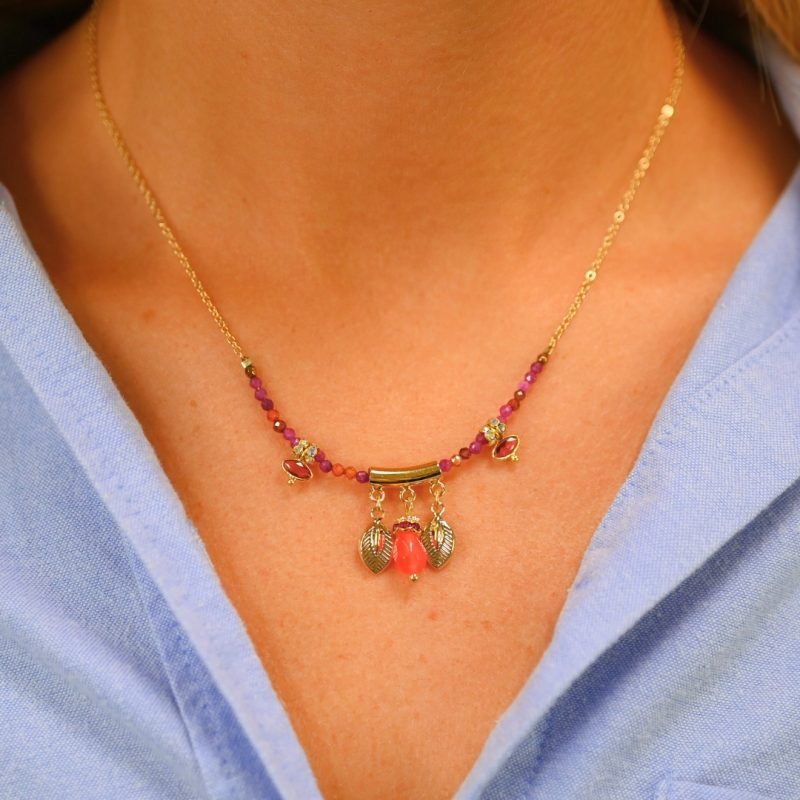 "Les pampilles feuilles rappellent l'univers luxuriant des motifs indiens, les rondelles de strass soulignent les pierres serties et les fines perles donnent du cachet à ce collier bohème! laiton doré à l’or fin 24 carats, cordon polyester et coton. Pierres serties (agate verte et tourmaline rose), jade teinté, perles en pierre semi-précieuses, strass . Bijou porté, Crédit GEMITY."
