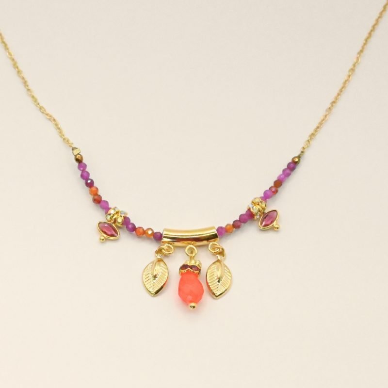 "Les pampilles feuilles rappellent l'univers luxuriant des motifs indiens, les rondelles de strass soulignent les pierres serties et les fines perles donnent du cachet à ce collier bohème! laiton doré à l’or fin 24 carats, cordon polyester et coton. Pierres serties (agate verte et tourmaline rose), jade teinté, perles en pierre semi-précieuses, strass . Bijou seul, Crédit GEMITY"