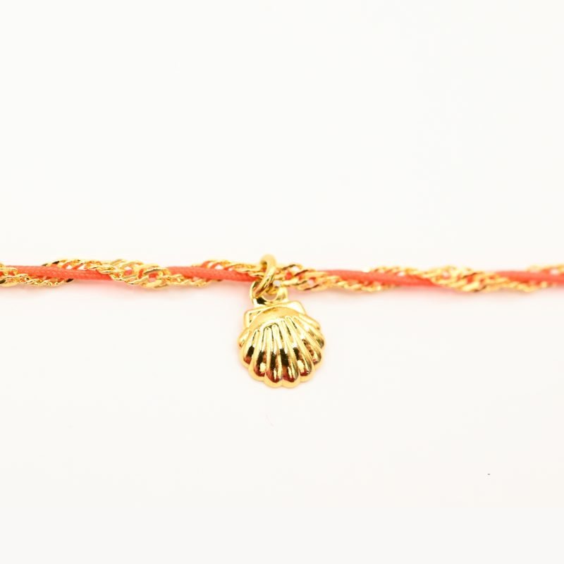 "L’élégance décontractée de la côte basque. Ce bracelet mêle fils de coton torsadé, touches dorées et couleurs vibrantes, pour une alliance parfaite entre raffinement et fraîcheur de l’océan. Orné d'un charm, il incarne une harmonie bohème et sophistiquée à porter au quotidien. Composition : Plaqué or et fils de coton torsadés. . Bijou seul, Crédit GEMITY"