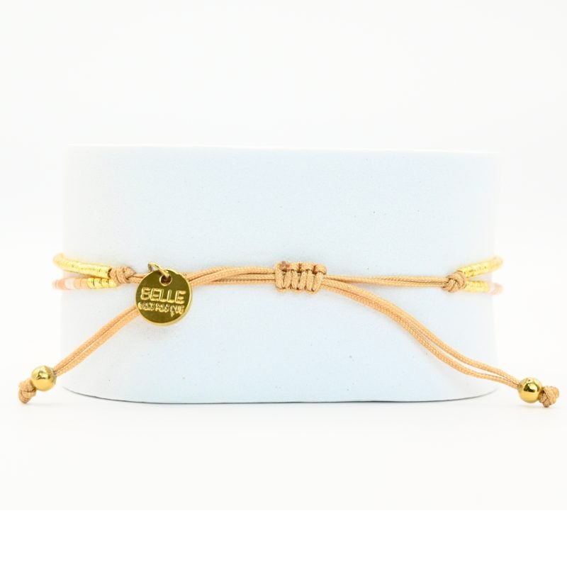 ce bracelet fin à 2 rangs associe des perles dorées, blanches, roses et nude pour un design doux et coloré. L'un des rangs est orné d’une perle plus grosse au centre, apportant une touche de sophistication à ce bijou délicat. . Bijou seul, Crédit GEMITY
