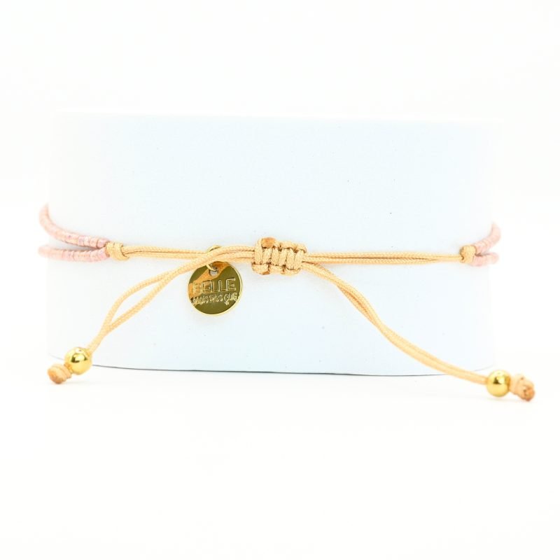 ce bracelet raffiné, composé de deux rangs, est l'accessoire parfait pour apporter de l'élégance à votre poignet. Le design associe des perles dorées et des perles nude, avec une disposition qui crée un équilibre parfait. . Bijou seul, Crédit GEMITY