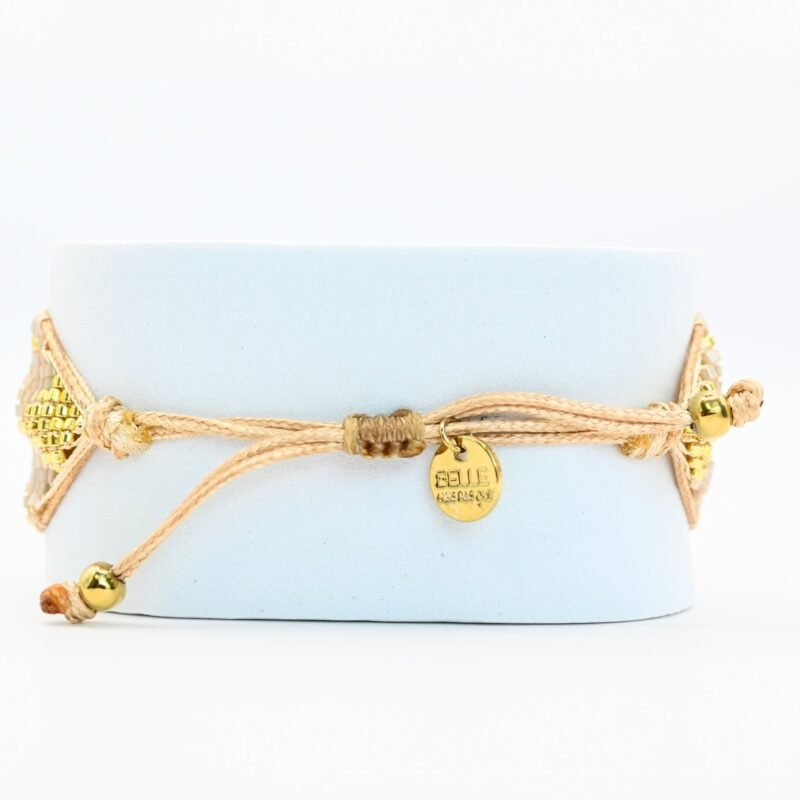 ajoutez une touche de sophistication à votre poignet avec cette grande manchette composée de 15 rangs de perles dorées et nude. Ce bijou élégant est sublimé par un ornement doré au centre, créant une harmonie parfaite entre luxe et simplicité.. Bijou seul, Crédit GEMITY