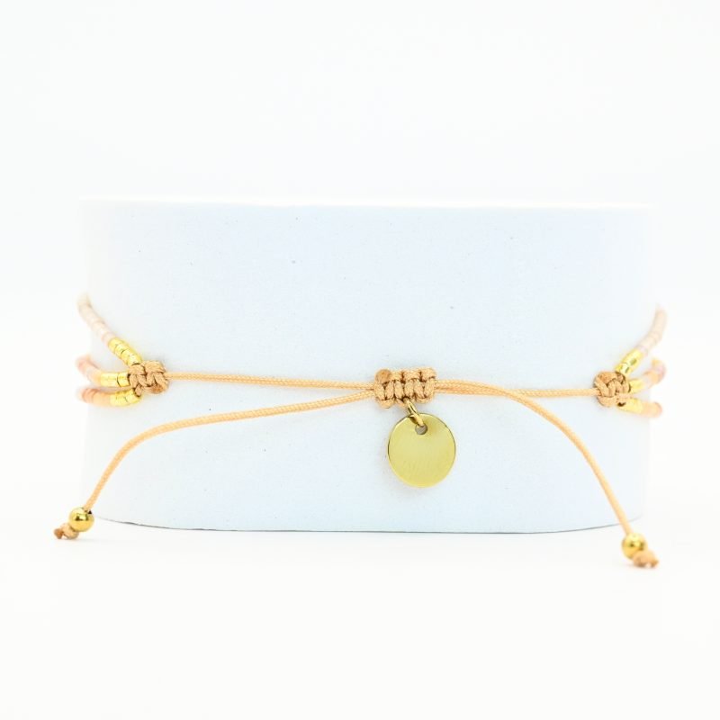 ce bracelet à 3 rangs combine des perles dorées, nude et rose poudré. Le second rang est orné d’un charm œil au centre, ajoutant une touche originale et élégante. . Bijou seul, Crédit GEMITY