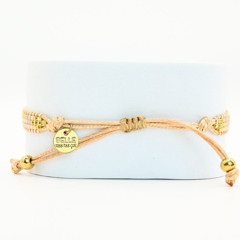 cette mini manchette élégante se compose de 3 rangs de perles nude, dorées et blanches, créant un design délicat et raffiné. . Bijou seul, Crédit GEMITY