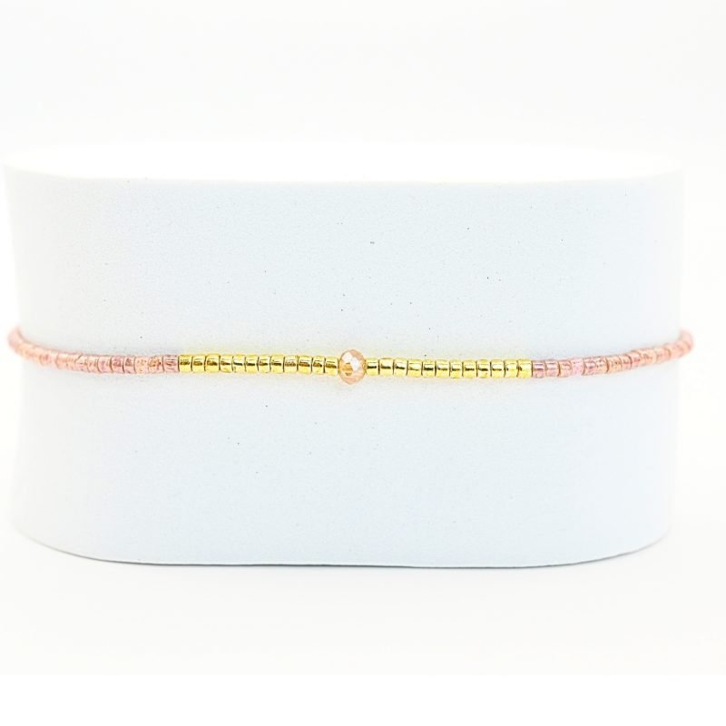 ce bracelet fin à cordon ajustable. Composé de perles nude délicates et de perles dorées au centre, ce bijou 1 rang se marie facilement avec toutes vos tenues. . Bijou seul, Crédit GEMITY