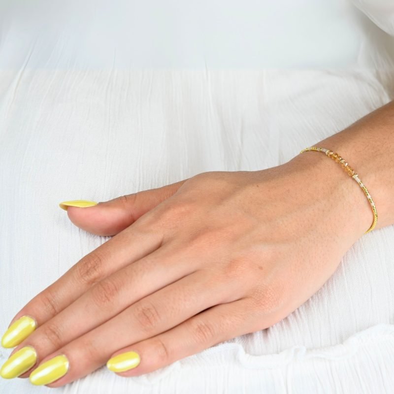 un bracelet délicat et lumineux, parfait pour tous les jours ! Son cordon ajustable s’adapte à toutes les tailles, tandis que ses perles dorées et nude apportent une touche douce et élégante. . Bijou porté, Crédit GEMITY.