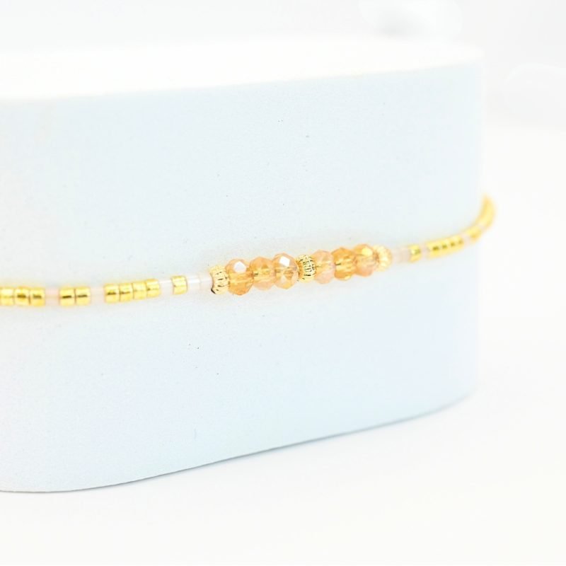un bracelet délicat et lumineux, parfait pour tous les jours ! Son cordon ajustable s’adapte à toutes les tailles, tandis que ses perles dorées et nude apportent une touche douce et élégante. . Bijou seul, Crédit GEMITY