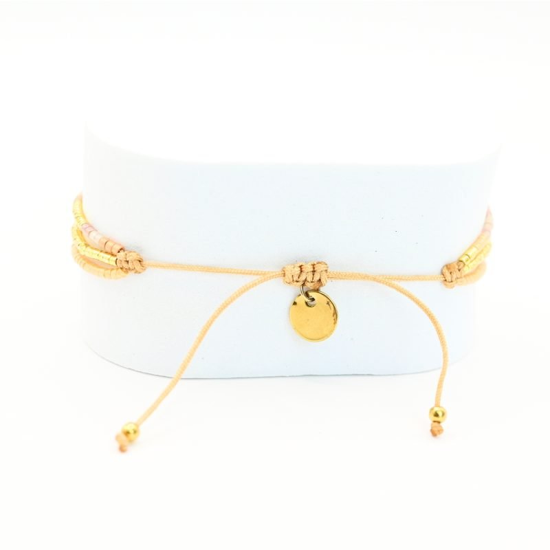 ce bracelet raffiné à 3 rangs combine des perles dorées et nude pour un look élégant et féminin. Le premier rang est orné de perles délicates, tandis que le second présente des perles plus grosses, créant un effet visuel dynamique. Le troisième rang se distingue par un charm étoile au centre, ajoutant une touche de magie et de sophistication. . Bijou seul, Crédit GEMITY