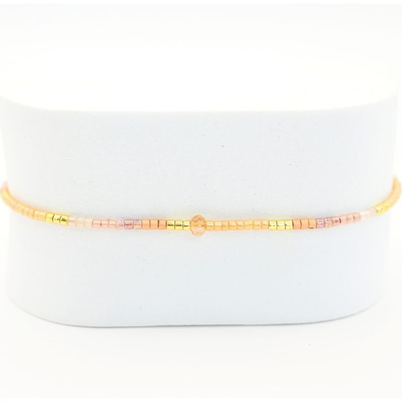 " ce bracelet délicat allie finesse et élégance avec son cordon ajustable et ses perles dorées et rose poudré. . Bijou seul, Crédit GEMITY"