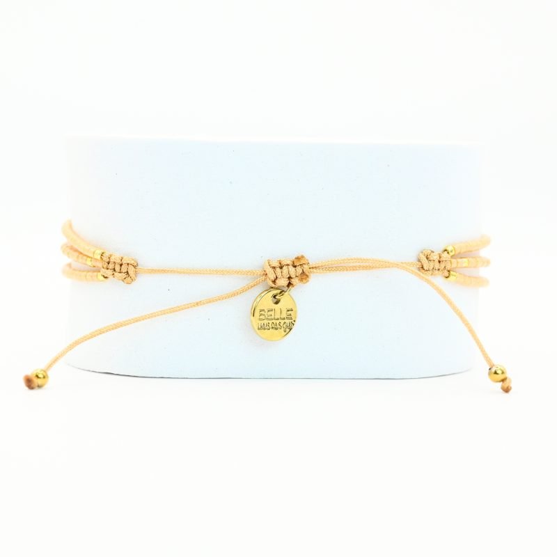 ce bracelet fin à 3 rangs est principalement composé de perles nude, avec quelques touches subtiles de perles dorées, créant un look délicat et élégant. Les trois rangs sont réunis par deux ornements en forme de lune, apportant une touche mystique et raffinée. . Bijou seul, Crédit GEMITY