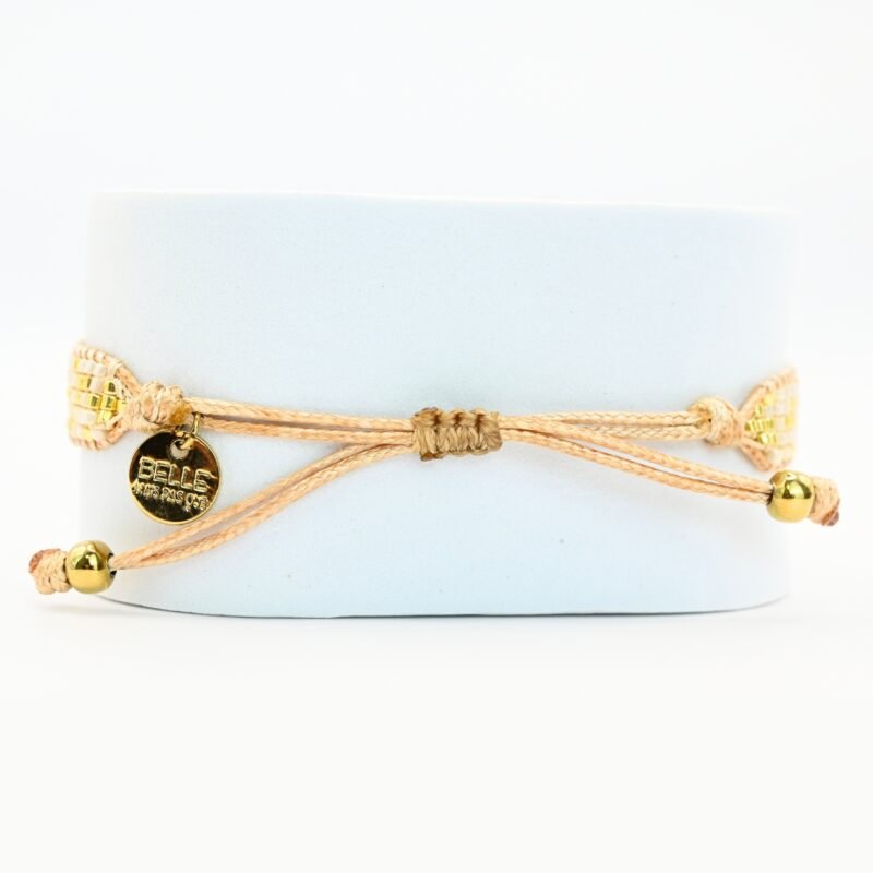 cette petite manchette raffinée se compose de 5 rangs de perles blanches, offrant une touche lumineuse et élégante. Son ornement central en forme d'œil apporte une symbolique protectrice et tendance. . Bijou seul, Crédit GEMITY
