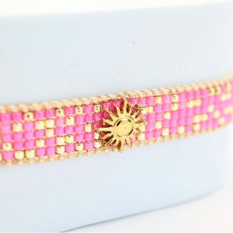 audacieuse et éclatante, cette petite manchette illumine votre poignet avec ses 5 rangs de perles roses fluo. Son ornement central en forme de soleil apporte une touche lumineuse et rayonnante. . Bijou seul, Crédit GEMITY