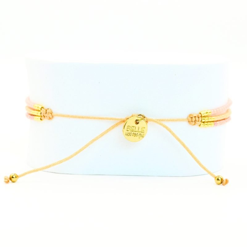 ce bracelet fin à 3 rangs regroupe des perles dorées et nude, créant un effet raffiné et élégant. L'ornement central rassemble les rangs pour un look harmonieux et sophistiqué. . Bijou seul, Crédit GEMITY