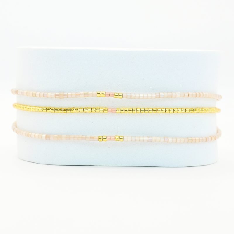 ce bracelet élégant à 3 rangs combine des perles dorées sur le premier rang et des perles blanches sur les deux autres, créant un look raffiné et lumineux. . Bijou seul, Crédit GEMITY