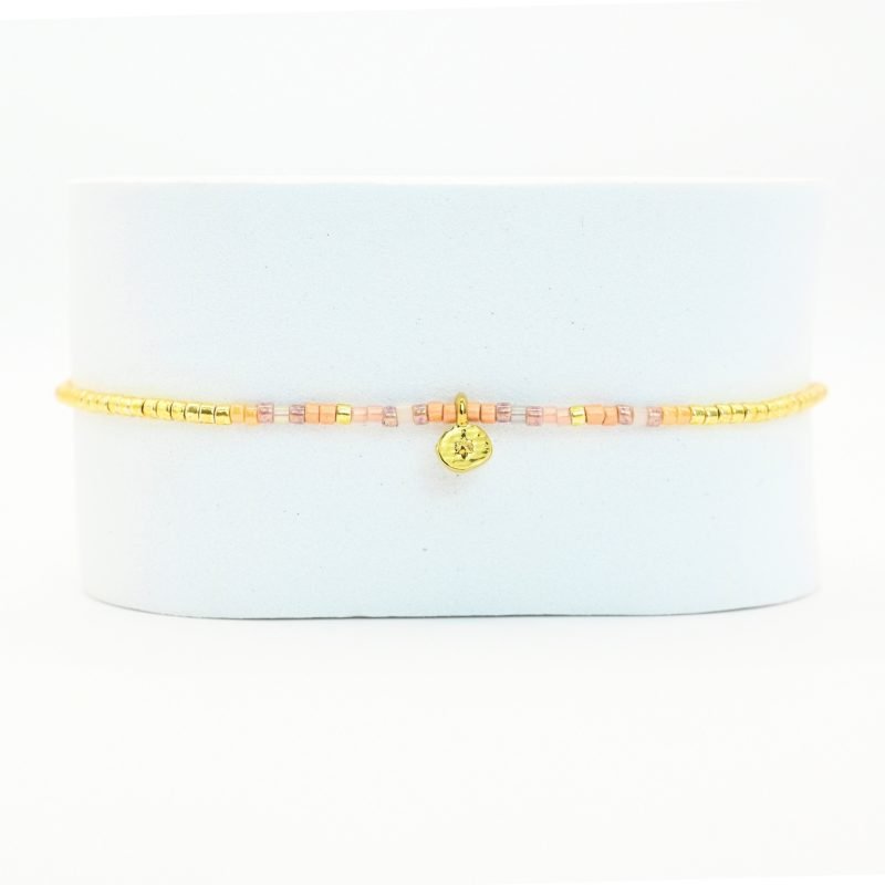 ce bracelet fin au design délicat est le parfait accessoire pour apporter une touche d’élégance subtile à votre poignet. Composé de perles dorées et nude, il se distingue par un charm ovale qui ajoute une note de raffinement. . Bijou seul, Crédit GEMITY