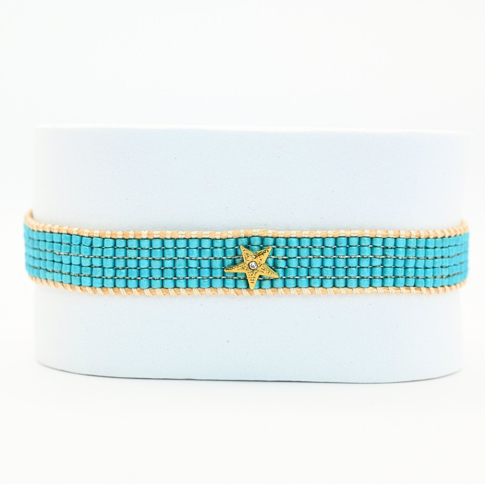 plongez dans l’univers rafraîchissant de cette petite manchette composée de 5 rangs de perles bleues lagon. Le contraste de ses perles vibrantes et l’ornement soleil en son centre créent une harmonie parfaite, évoquant l’éclat du ciel et de la mer. . Bijou seul, Crédit GEMITY