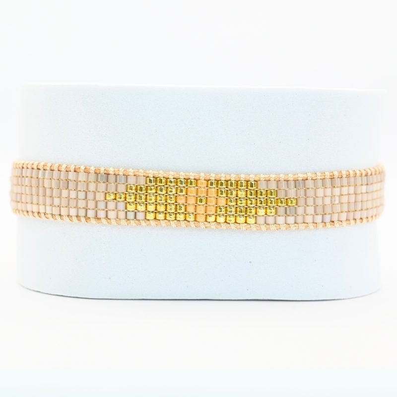cette petite manchette à 5 rangs associe des perles nude avec un centre doré et rose pour un design à la fois doux et lumineux. . Bijou seul, Crédit GEMITY