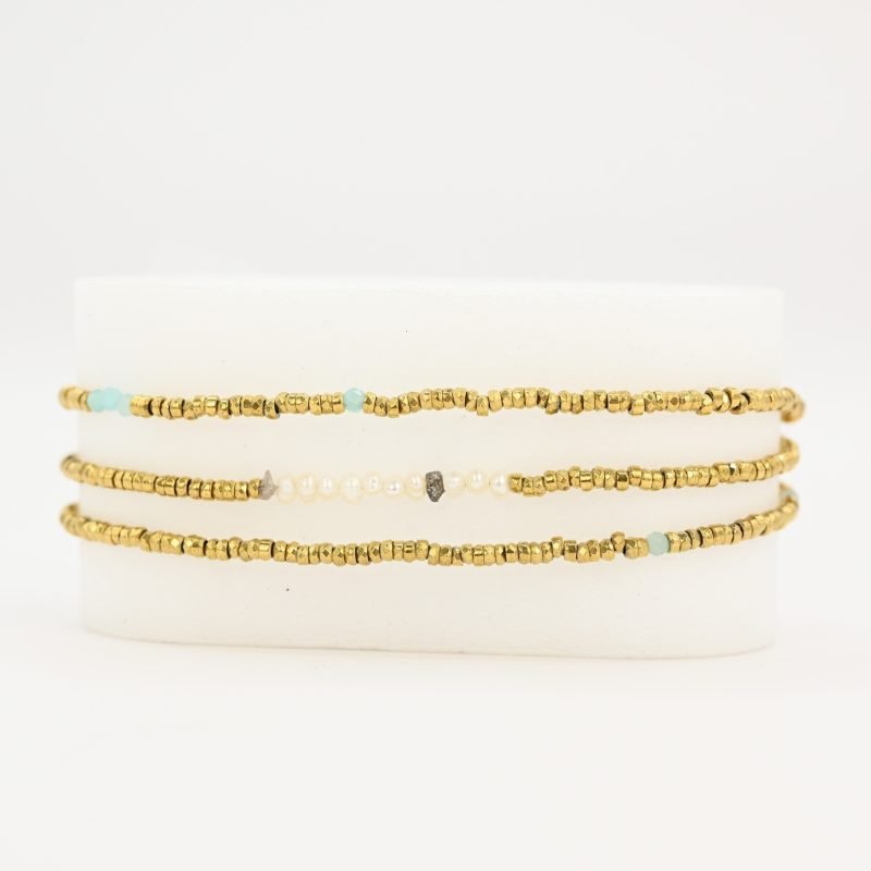 Ce bijou polyvalent se compose de petites perles dorées subtilement mises en valeur par quelques perles en nacre placées en son centre. . Bijou seul, Crédit GEMITY